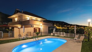 A two-story house with a swimming pool, outdoor seating, and a view of the surrounding hills. - Rustic Garden House, 4BD, 2BA, spacious, peaceful, 10min drive from citycenter (Chania)