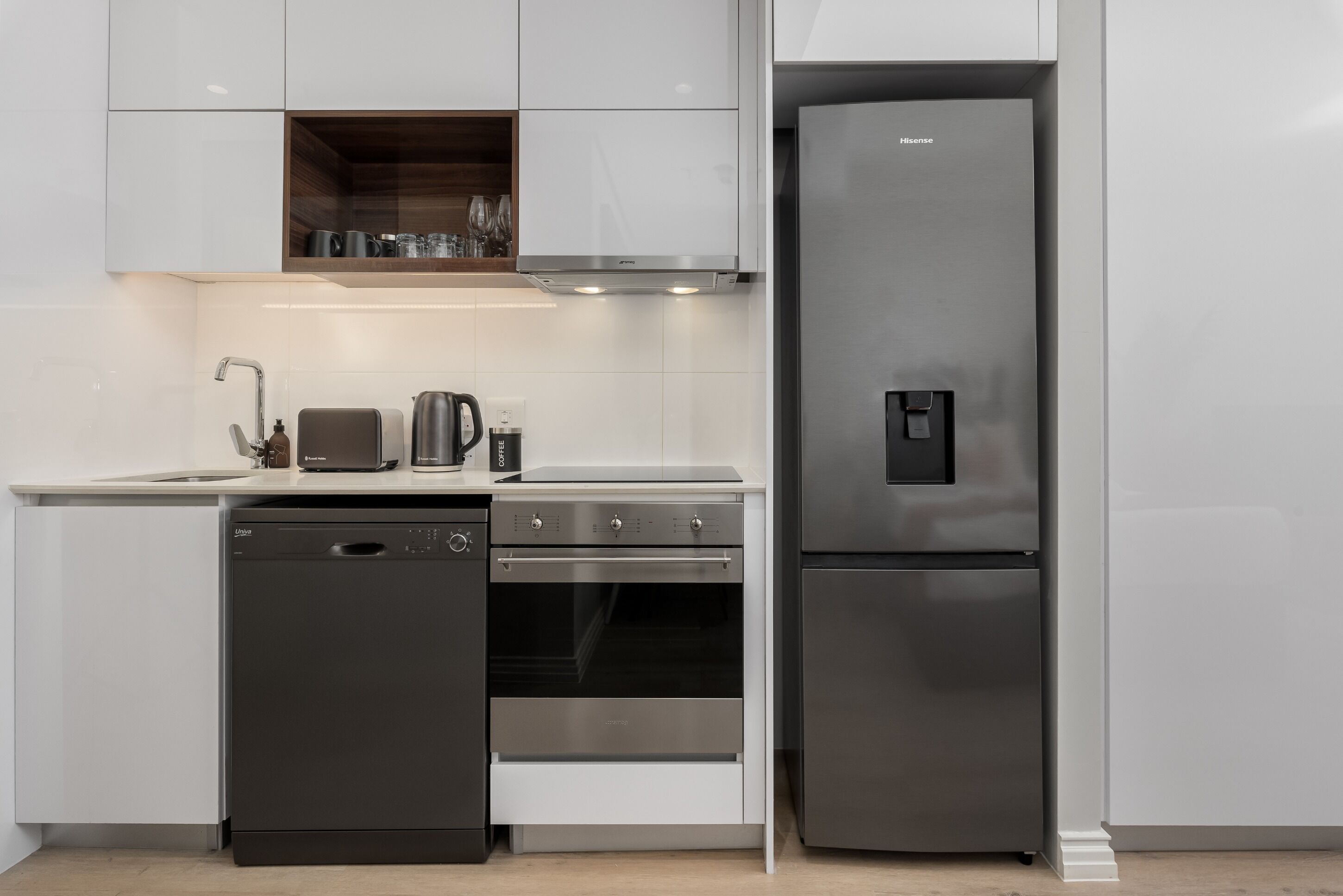 Una cocina moderna equipada con lavavajillas, horno y refrigerador de acero inoxidable.