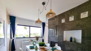 A modern kitchen with a white countertop, teal bowls, and a hanging light fixture.