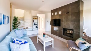 A modern living room with a sofa, coffee table, and a fireplace.