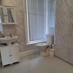 Ein Badezimmer mit Waschbecken, Toilette und Dusche.
