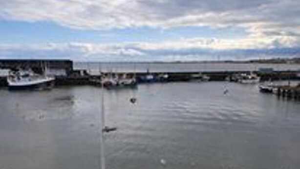 A harbor with boats docked at piers, calm water, and a cloudy sky. - Immaculate 2-bed Cottage - Free Wifi (Bridlington)