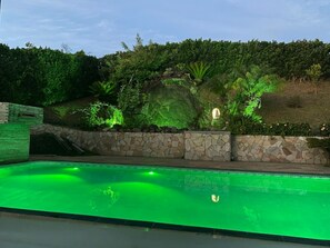 Relax by the pool surrounded by lush greenery.