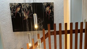 A wooden staircase with a modern light fixture.