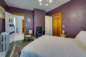 Ein Schlafzimmer mit einem großen Bett, einem Fernseher, einem Sessel und einer Kommode.