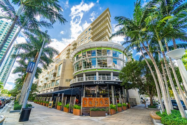 Experience the unique curved facade of this hotel, surrounded by lush palm trees and offering stunning views from large windows.