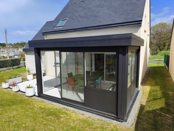 A modern house with a large glass extension, a tiled roof, and a small garden area. - Dahouët - Charmante maison pour 6 voyageurs (Pléneuf-Val-André)