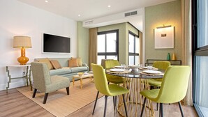 A modern living room with a sofa, coffee table, and a dining area with chairs and a table. - Genteel Home Betis XXII (Seville)