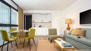 A modern living room with a sofa, a coffee table, and a dining area with chairs and a table. - Genteel Home Betis XXII (Seville)