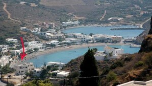 Un pueblo costero con edificios blancos, una playa y un litoral rocoso.