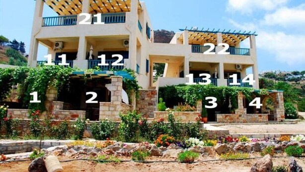 A multi-story building with balconies, numbered rooms, and a landscaped garden area. - Aronis Studios Triple bed with View & Patio 03 (Kapsáli)
