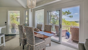 A dining area with wicker chairs, a wooden table, and a chandelier. - Private Home, Marsh Front Gorgeous View 874 Fiddlers Ridge (Fripp Island)