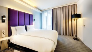 A hotel room with a large bed, a desk, a lamp, and a window with curtains. - Premier Inn Heilbronn City Centre (Heilbronn)