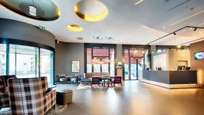A modern lobby with a reception desk, seating area, and large windows. - Premier Inn Heilbronn City Centre (Heilbronn)