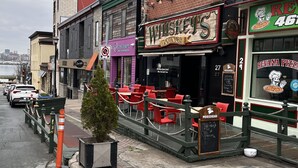 A street view with a row of buildings, including a restaurant named 'Whiskey Lounge' and a pizza place 'Revana Pizza'.