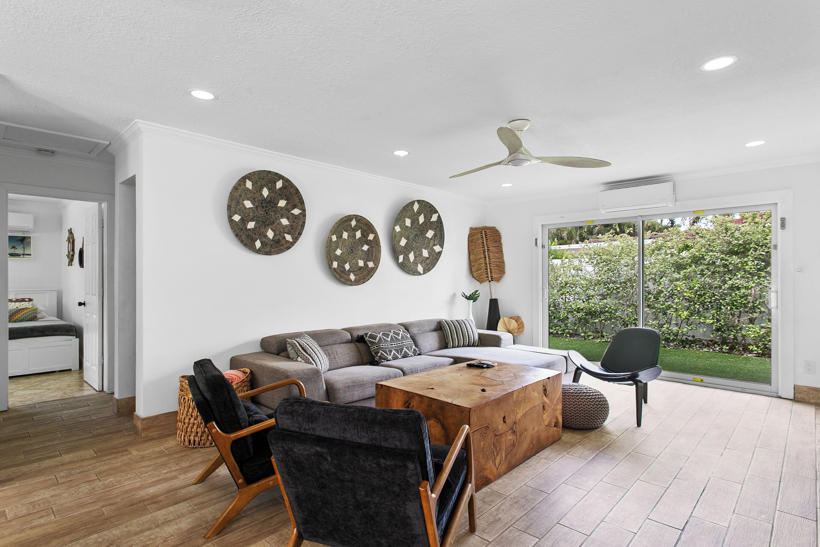 Ein stilvolles Wohnzimmer mit Sofa, Sesseln, Couchtisch und dekorativen Wandbildern.