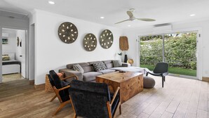 A modern living room with a sofa, chairs, a coffee table, and decorative wall art. - Private Beach Club, Heated Pool, Jacuzzi, & 6 Seater Golf Cart Included!  (Pompano Beach)