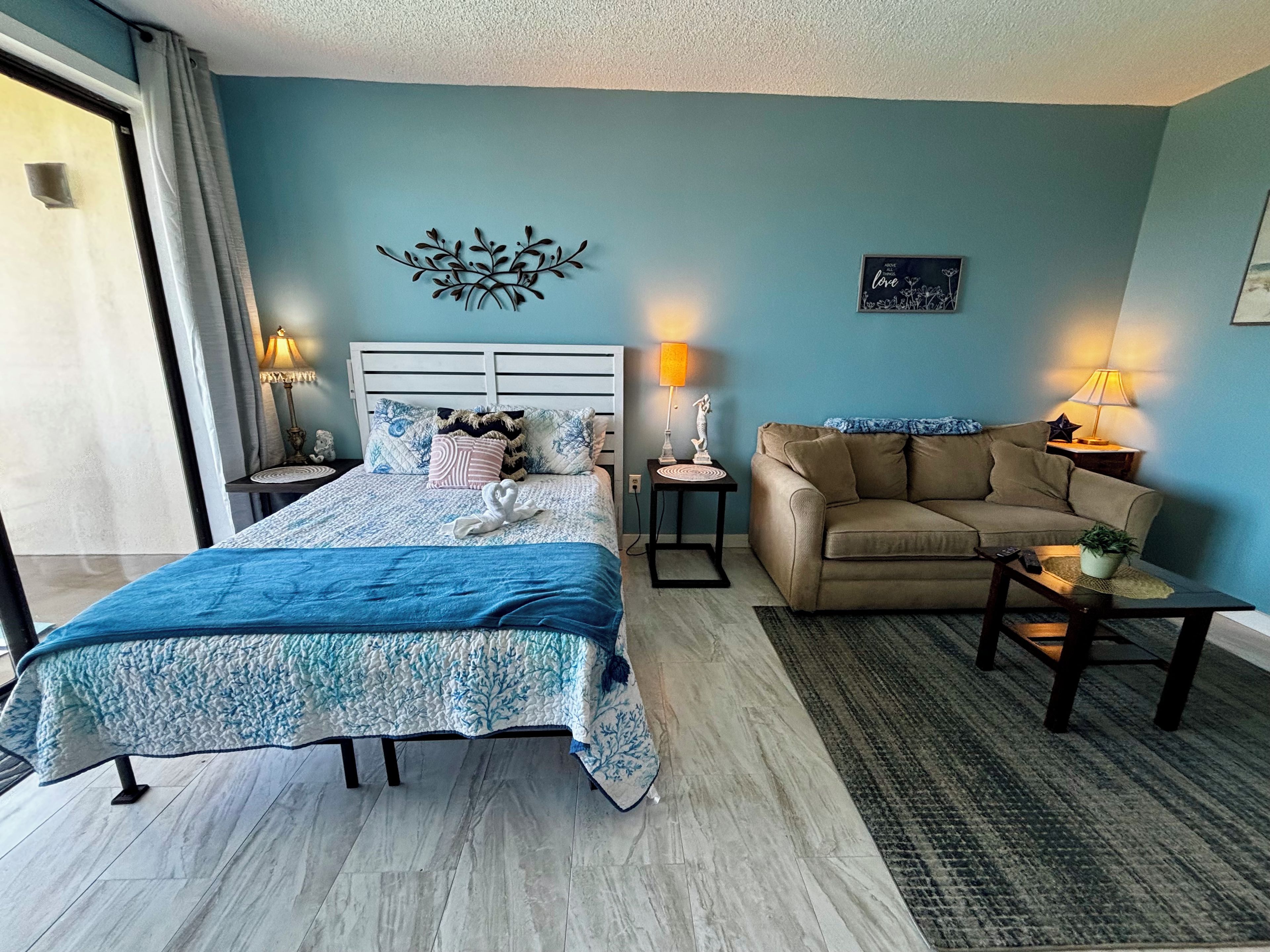 Ein Schlafzimmer mit einem Bett, einem Sofa und einer Wanddekoration.