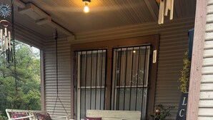 A porch with a bench, potted plants, and a welcome sign. - The Lyons Den - Great work place with high speed internet near downtown.  (Jackson)