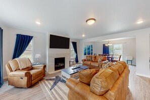 Relax in a stylish living room with a leather sofa, flat-screen TV, and cozy fireplace.
