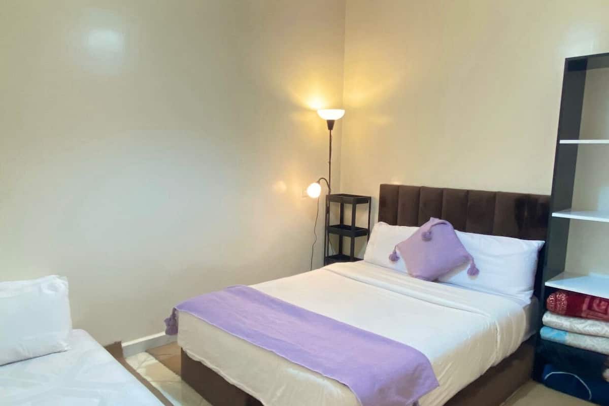 Une chambre à coucher avec un lit, une table de chevet, une lampe et une armoire.