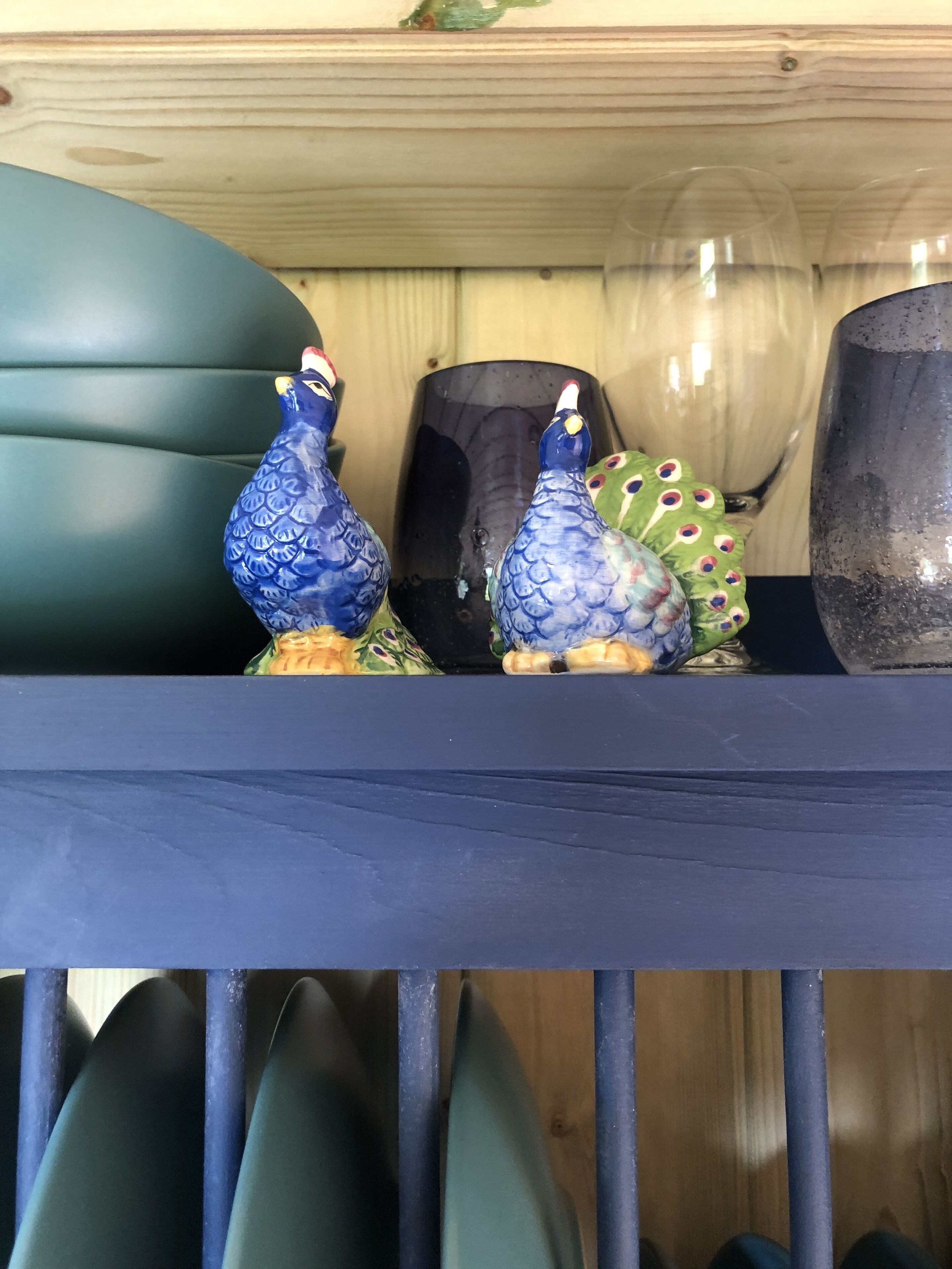 A shelf with decorative ceramic birds and a black vase.