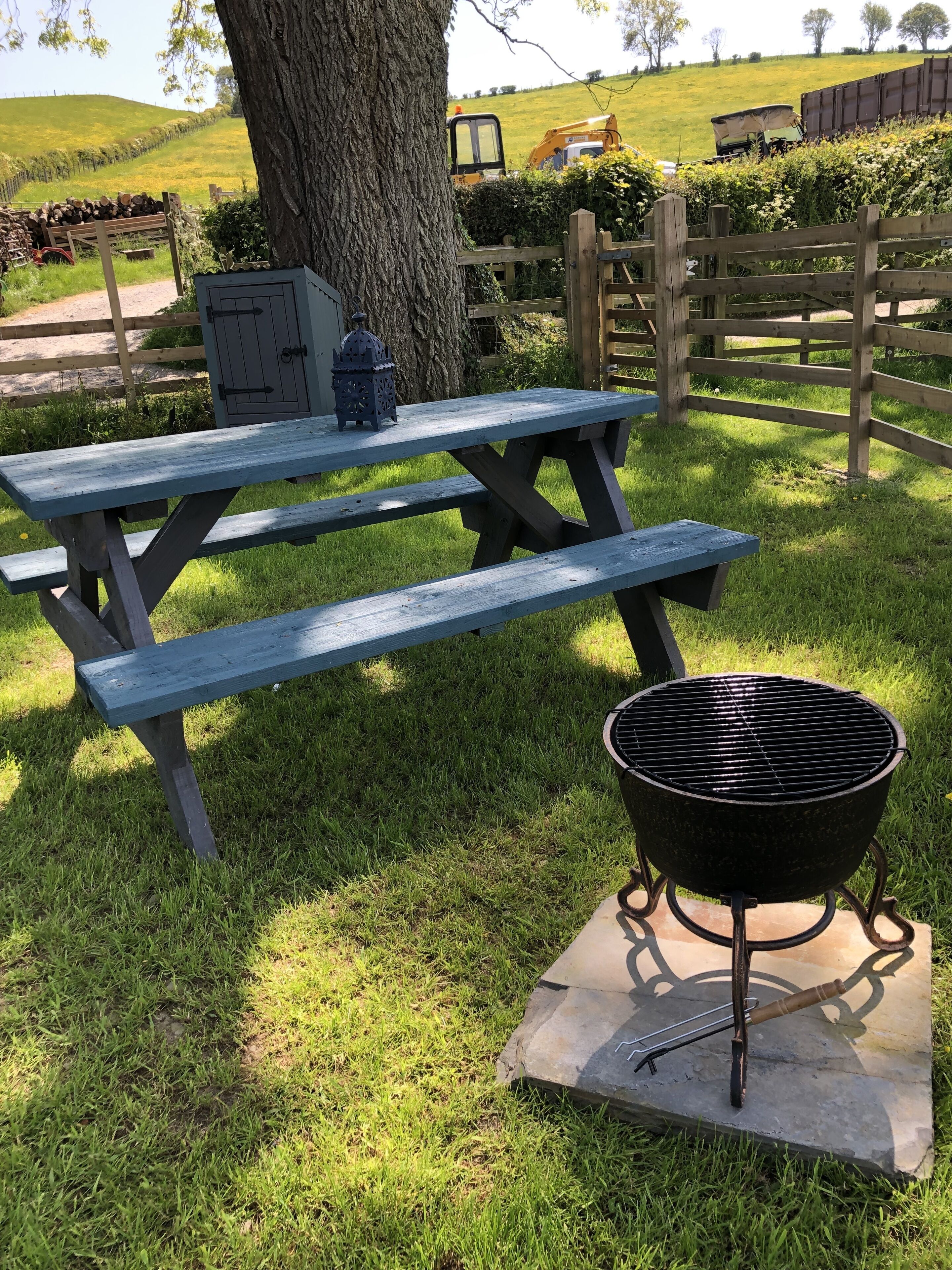 Ett picknickbord med en grill och en lykta.