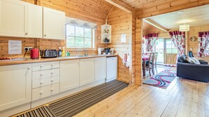 L’intérieur d’une cabane en bois comprend une cuisine, un coin repas et un salon.