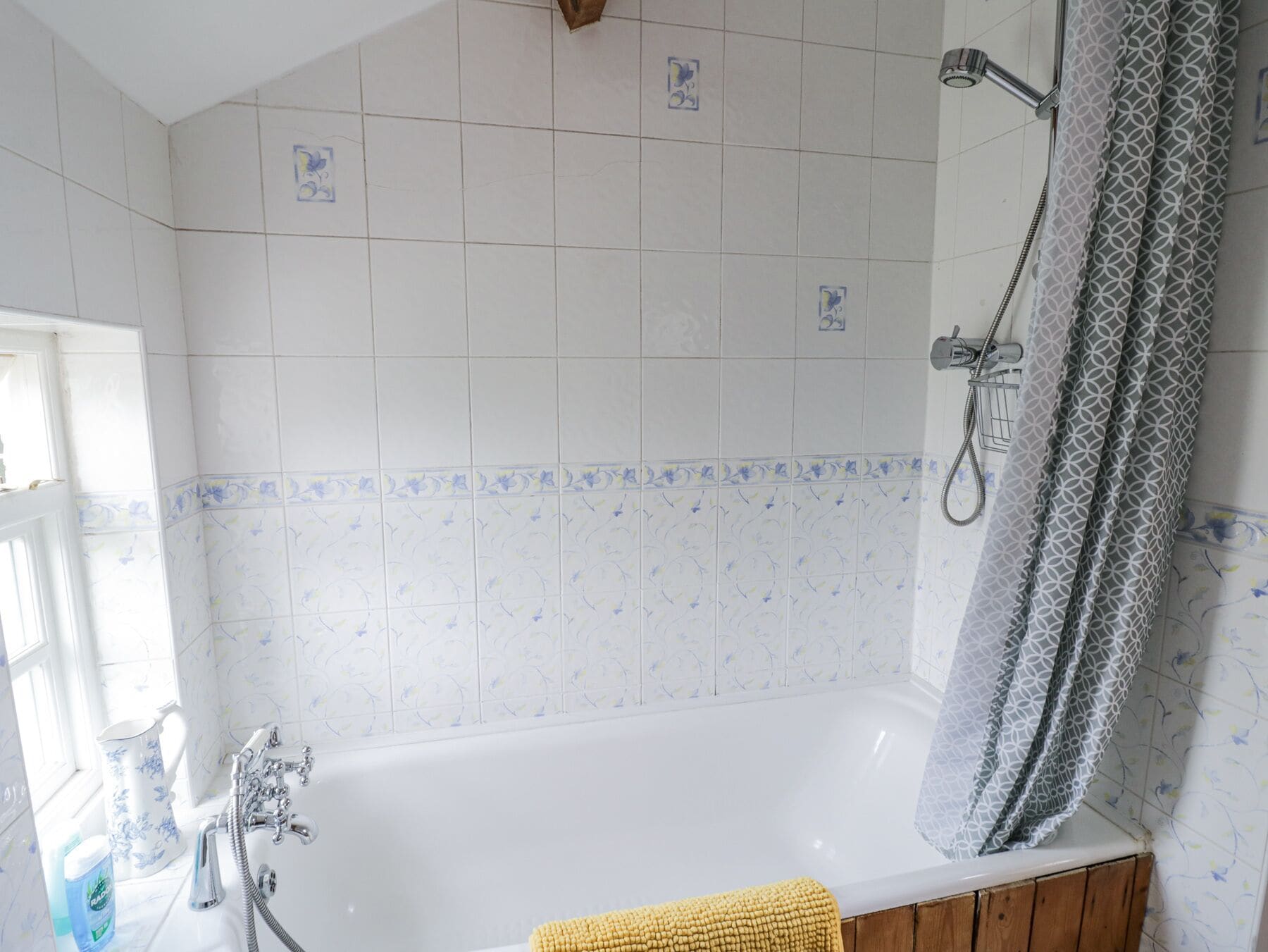 Ein Badezimmer mit Badewanne, Dusche und einem Fenster mit Blick.
