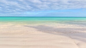 A beach with clear turquoise water and a sandy shore under a partly cloudy sky. - Marina Oasis Retreat at Fishing Lodge, Cap Cana (Punta Cana)