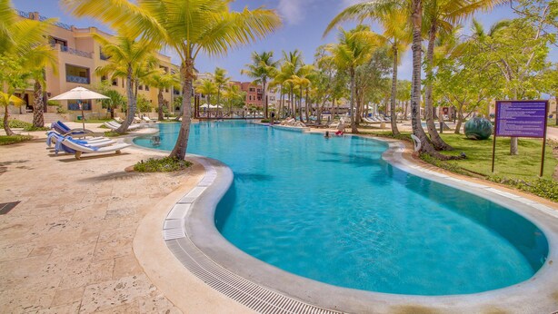 A swimming pool with lounge chairs and palm trees. - Marina Oasis Retreat at Fishing Lodge, Cap Cana (Punta Cana)