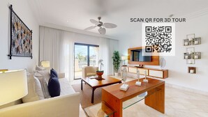 A modern hotel room with a sofa, a coffee table, a TV, and a balcony with curtains. - Marina Oasis Retreat at Fishing Lodge, Cap Cana (Punta Cana)