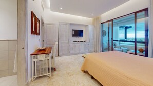 A bedroom with a bed, a TV, a dining table, and a view of the sea. - 2BDR Cap Cana Retreat @ GBL (Punta Cana)