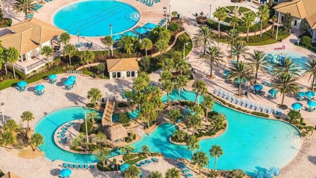 An aerial view of a resort with multiple swimming pools, palm trees, and lounge areas. - CG236OCA - Luxury 5BR-4BA Villa with Private Pool (Davenport)