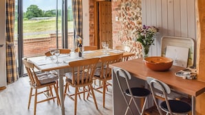 Un coin repas avec une table en bois, des chaises et un vase de fleurs.