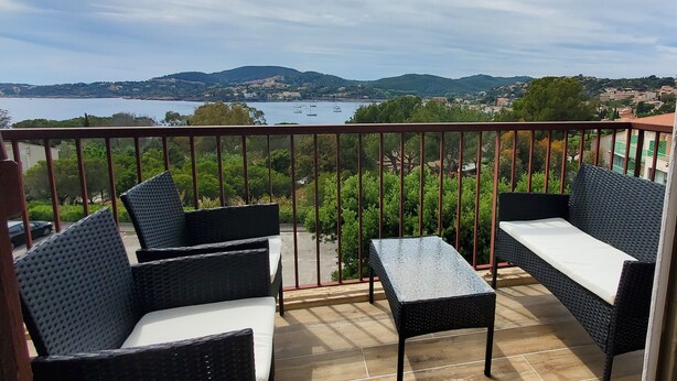 A balcony with wicker furniture and a view of a lake and hills. - Lumineux appartement avec vue sur mer (Saint-Raphaël)