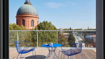 Ein Balkon mit Blick auf ein großes Kuppelgebäude, einem Tisch mit Stühlen und einem Geländer.