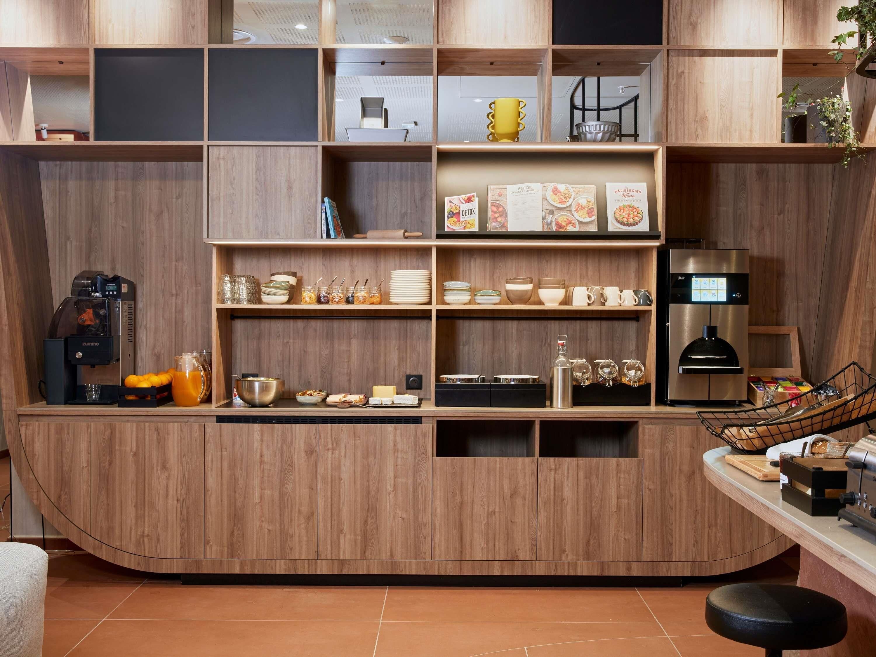 A modern kitchen with wooden cabinetry, a built-in coffee machine, and various kitchen appliances.