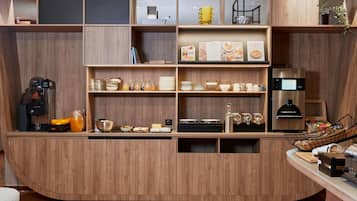 A modern kitchen with wooden cabinetry, a built-in coffee machine, and various kitchen appliances.