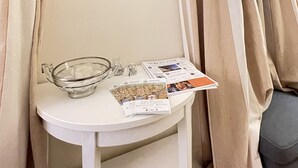 A room with a framed painting on the wall, a small table with a glass bowl, and a newspaper. - Cozy apartment-Florence old center-Duomo-Uffizi-2 bedrooms-2 bathrooms   (Firenze)