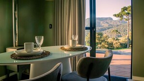 A dining area with a table, chairs, and a view of the outdoors. - Cabanas Sunset View (Urubici)