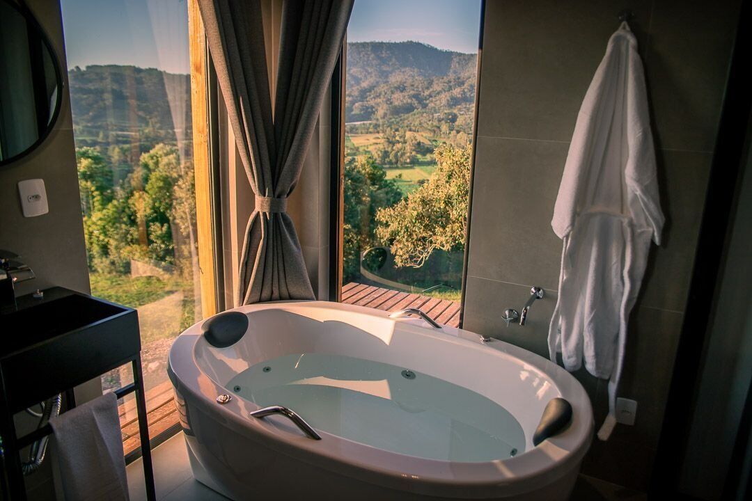 Une salle de bain avec une grande baignoire, un miroir, un lavabo et un porte-serviettes.