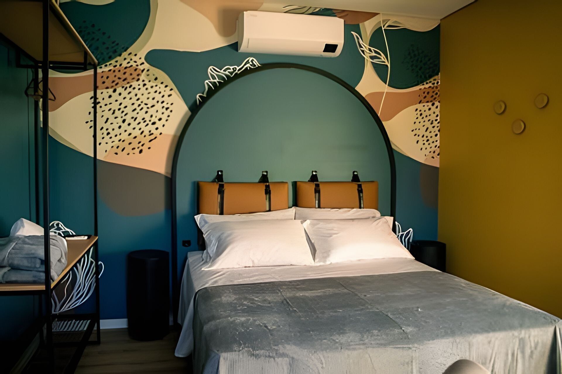 Uma cama com cabeceira, uma mesa de cabeceira e um ar condicionado fixado na parede.