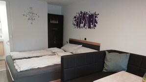 Ein modernes Schlafzimmer mit Bett, Sofa und kleinem Tisch.