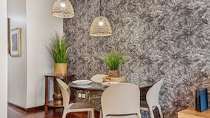 Een eetruimte met een wand in marmerlook, twee hangende lampen en een tafel gedekt met borden en stoelen.