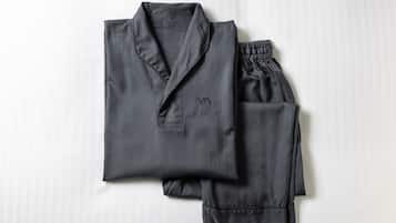 Un conjunto de pijamas de color oscuro, doblados cuidadosamente sobre un fondo blanco.