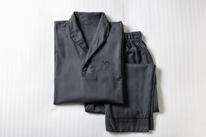 A neatly folded set of dark-colored pajamas on a white background.