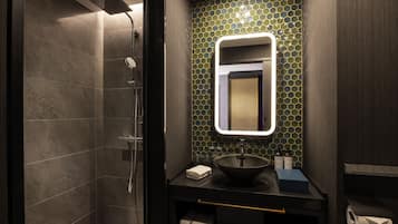 A modern bathroom with a shower, a sink with a mirror, and a tiled backsplash.
