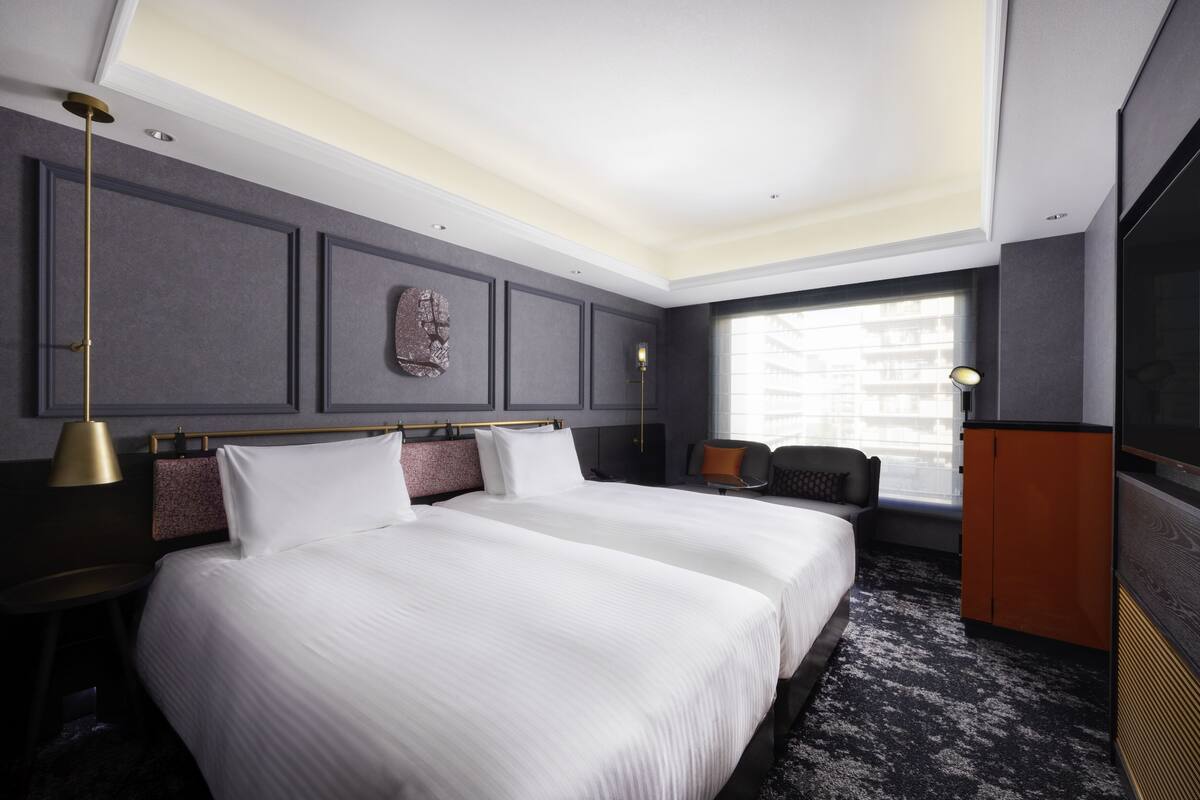 Habitación de hotel con una cama grande, un escritorio, una silla, un armario y una ventana con vistas.