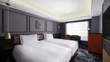 A hotel room with a large bed, a desk, a chair, a wardrobe, and a window with a view.